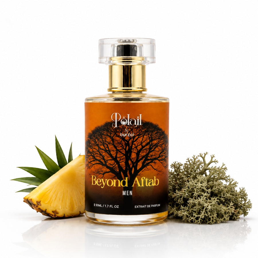 A bottle of polail by burzai beyond aftab Men perfume , styled with a pineapple slice and dried sea plants on a reflective white surface.
