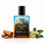 A rectangular perfume bottle of Polail by burzai Khpal Waziristan Women perfume with a black cap stands on a white reflective surface. The bottle contains a blue-to-orange gradient liquid and features a scenic mountain label.